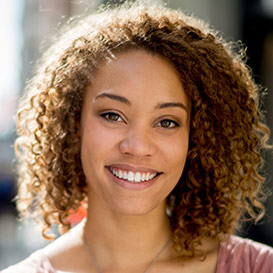 Young woman with brown curly hair smiling