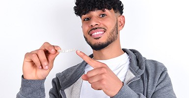 Man pointing to a SureSmile clear aligner in Odessa, TX